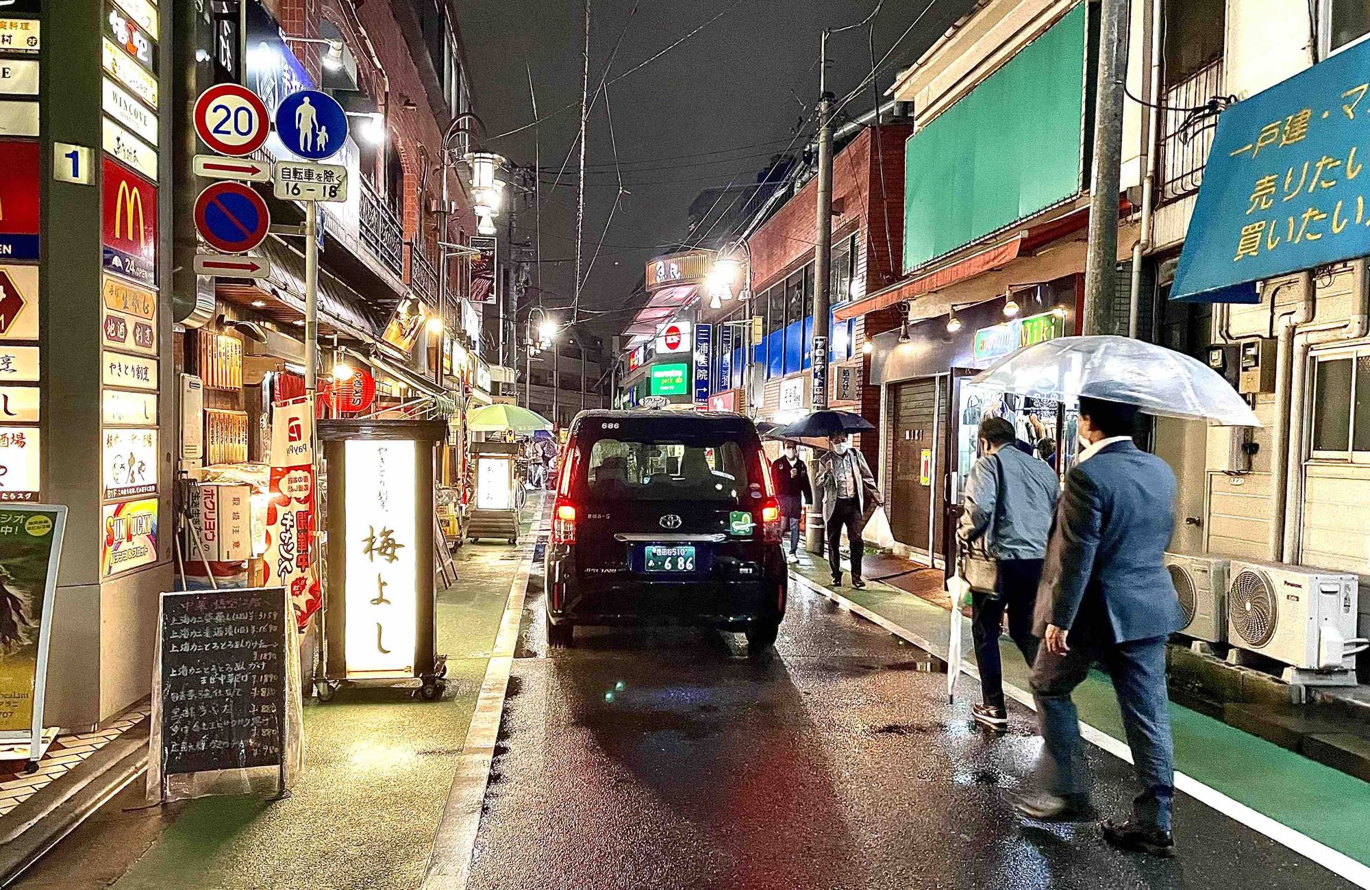 Taxi driving in shopping street in rain in Tokyo